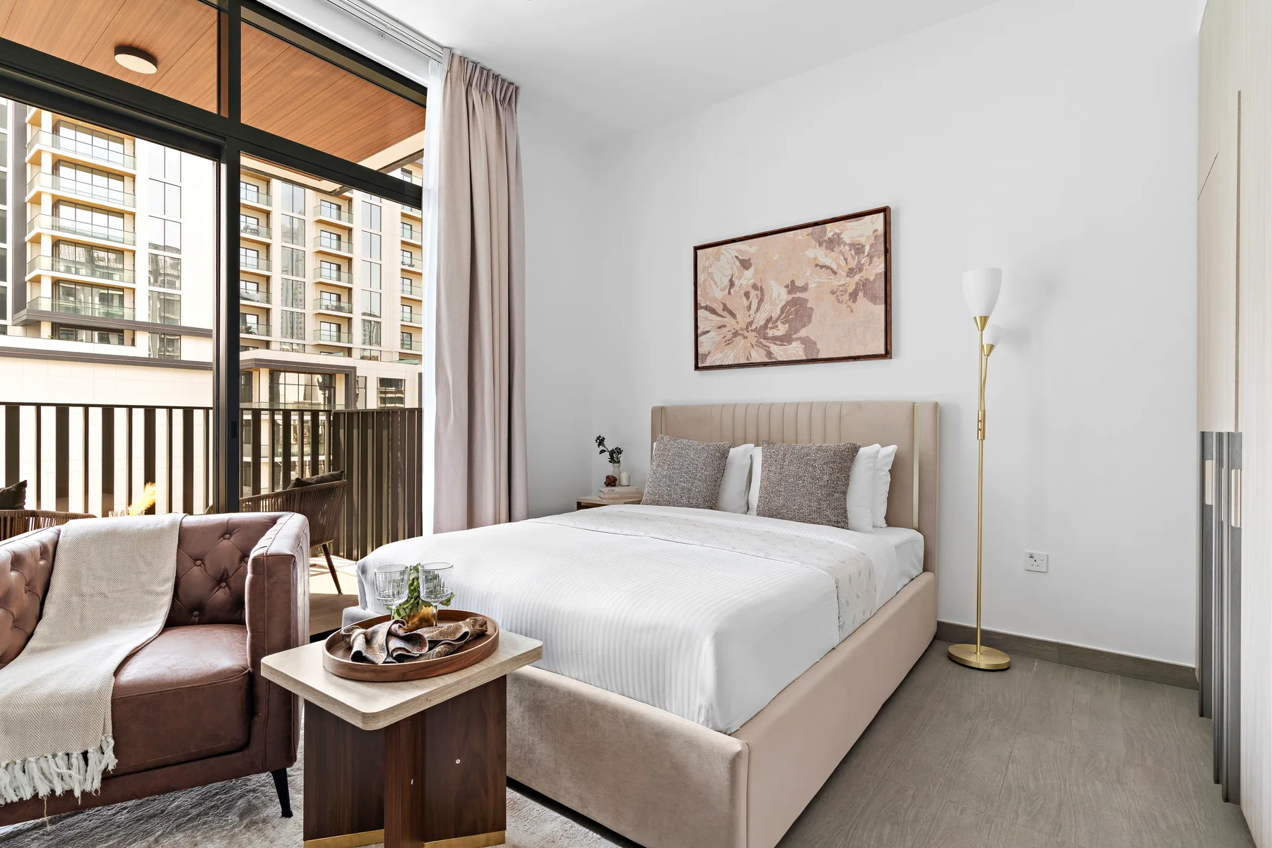 Un dormitorio con una cama junto a una ventana grande y un balcón.