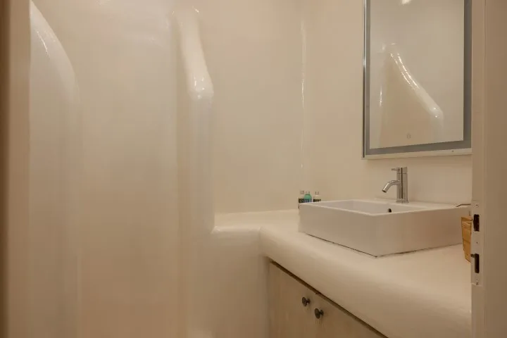 A bathroom with a white sink and a large mirror.