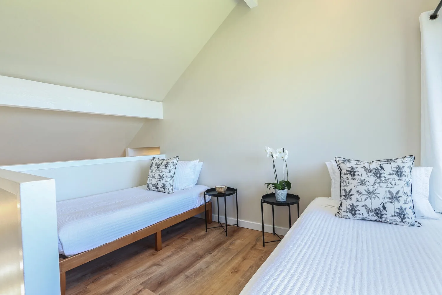 Un dormitorio con dos camas y una mesa pequeña entre ellas.
