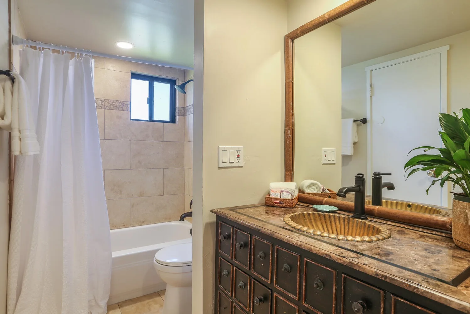 Un baño con bañera y un mueble con lavabo y espejo.