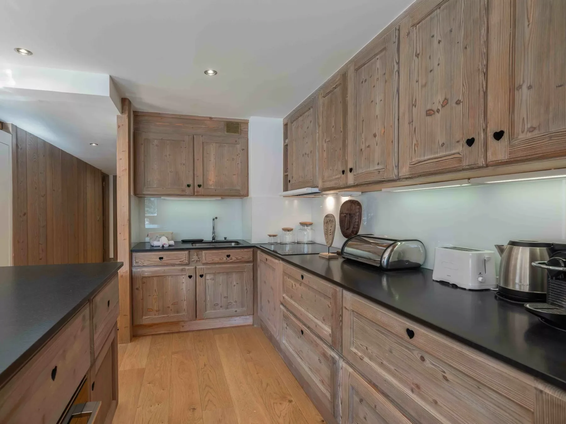 A kitchen with wooden cabinets and dark countertops.