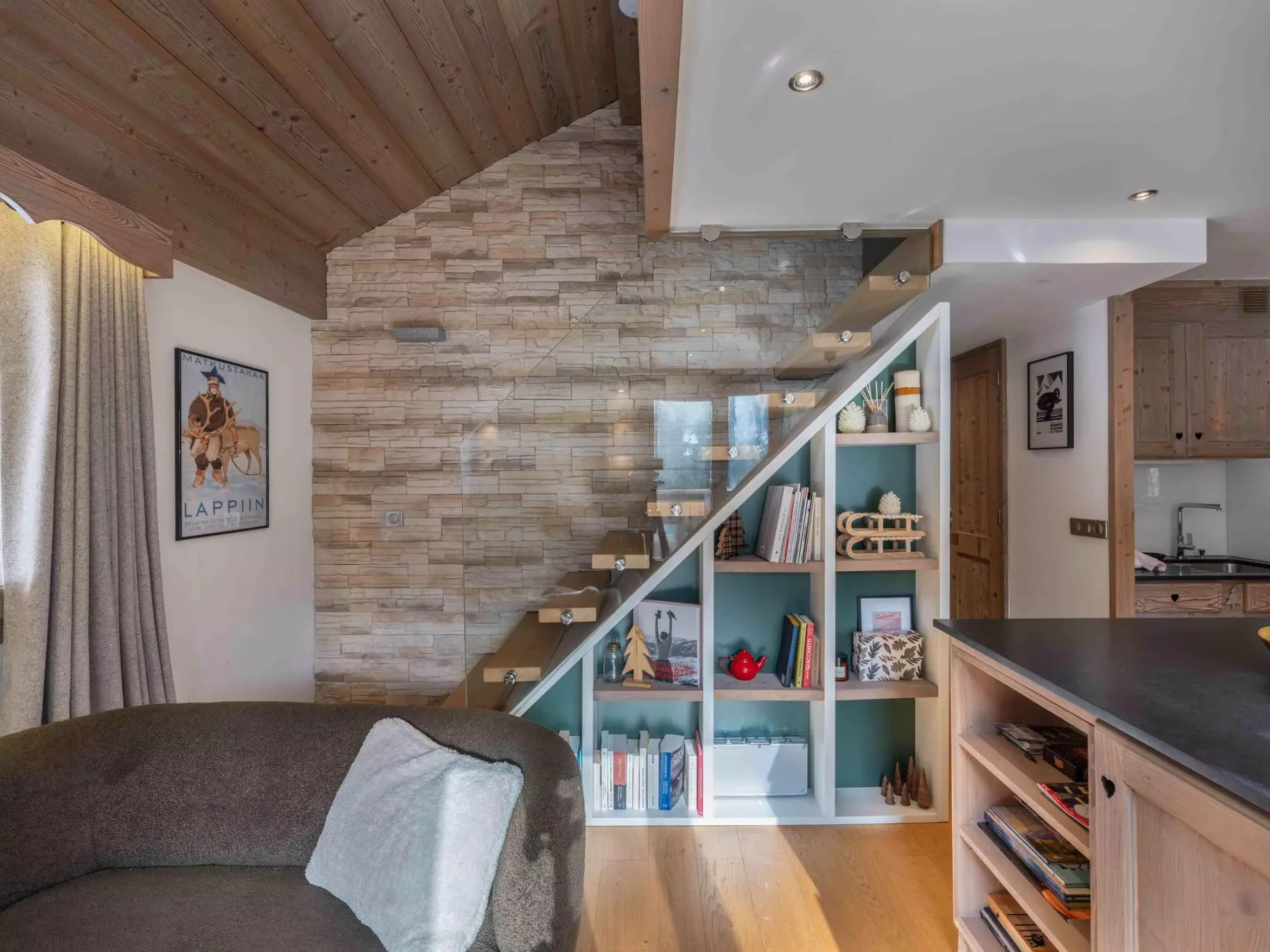 A living area with a staircase and built-in shelving beside the kitchen.