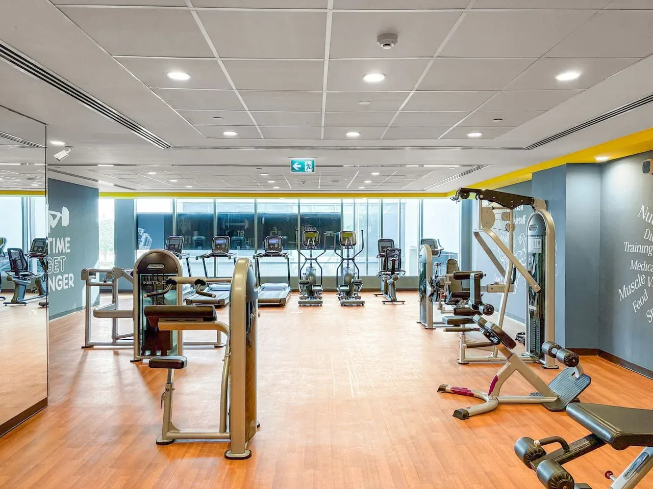 A gym with exercise machines and equipment arranged across the floor.