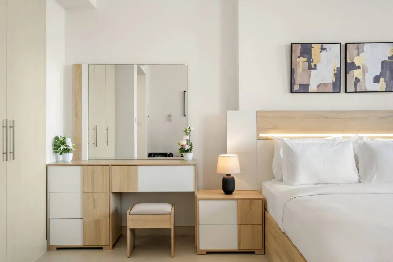 A bright bedroom with a bed, bedside table, and dressing table.