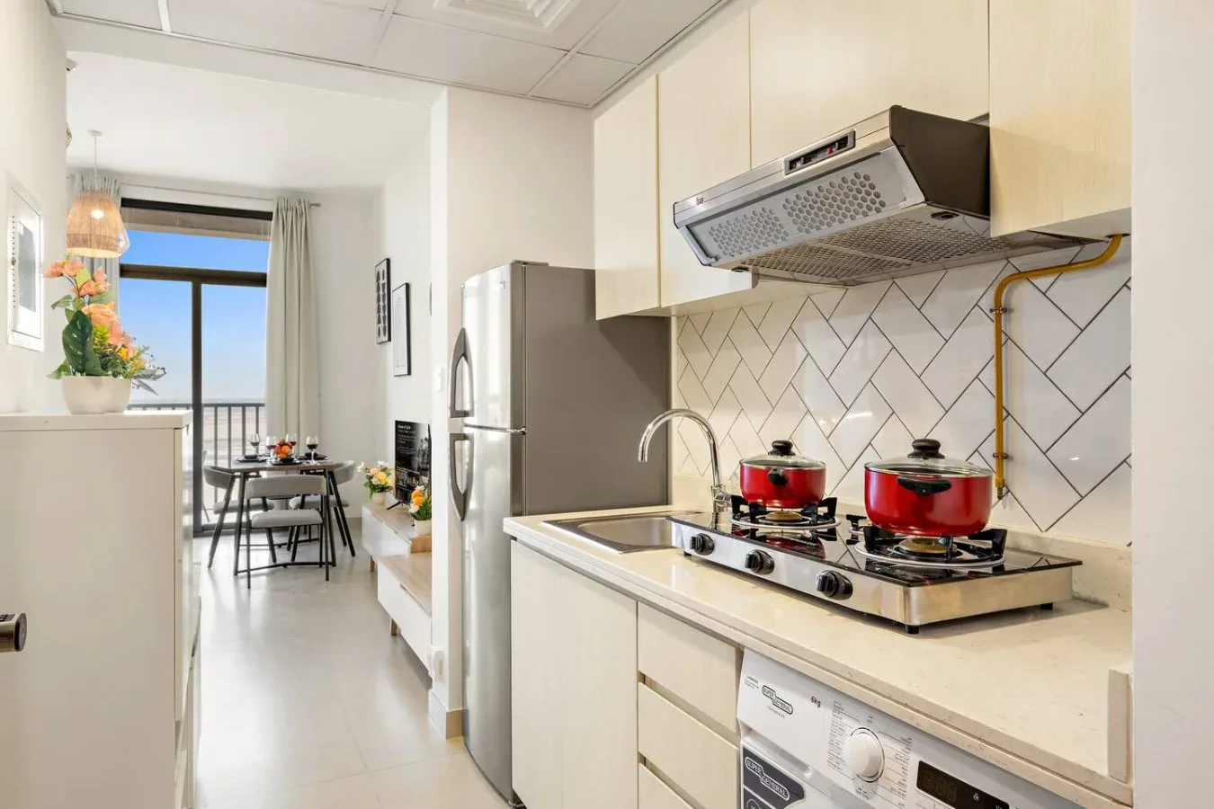 A bright kitchen with a tiled backsplash and a dining area by the window.
