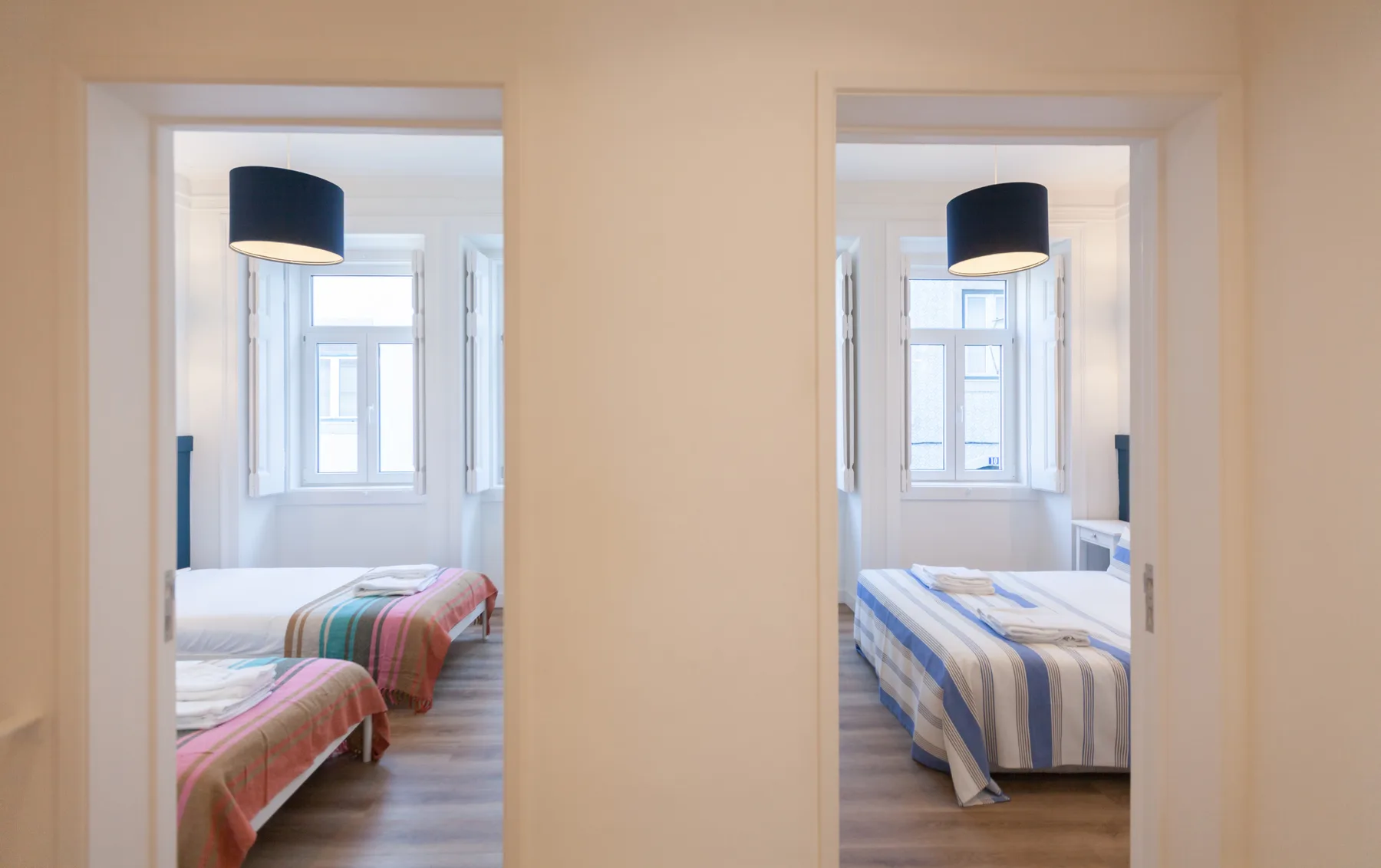 Two bedrooms are visible through separate doorways, each with a bed and window.