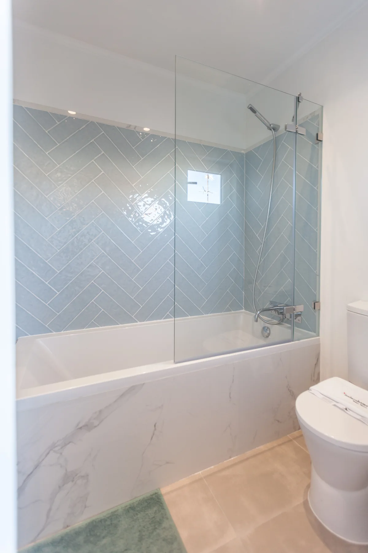 A bathroom with a tiled shower and a toilet.