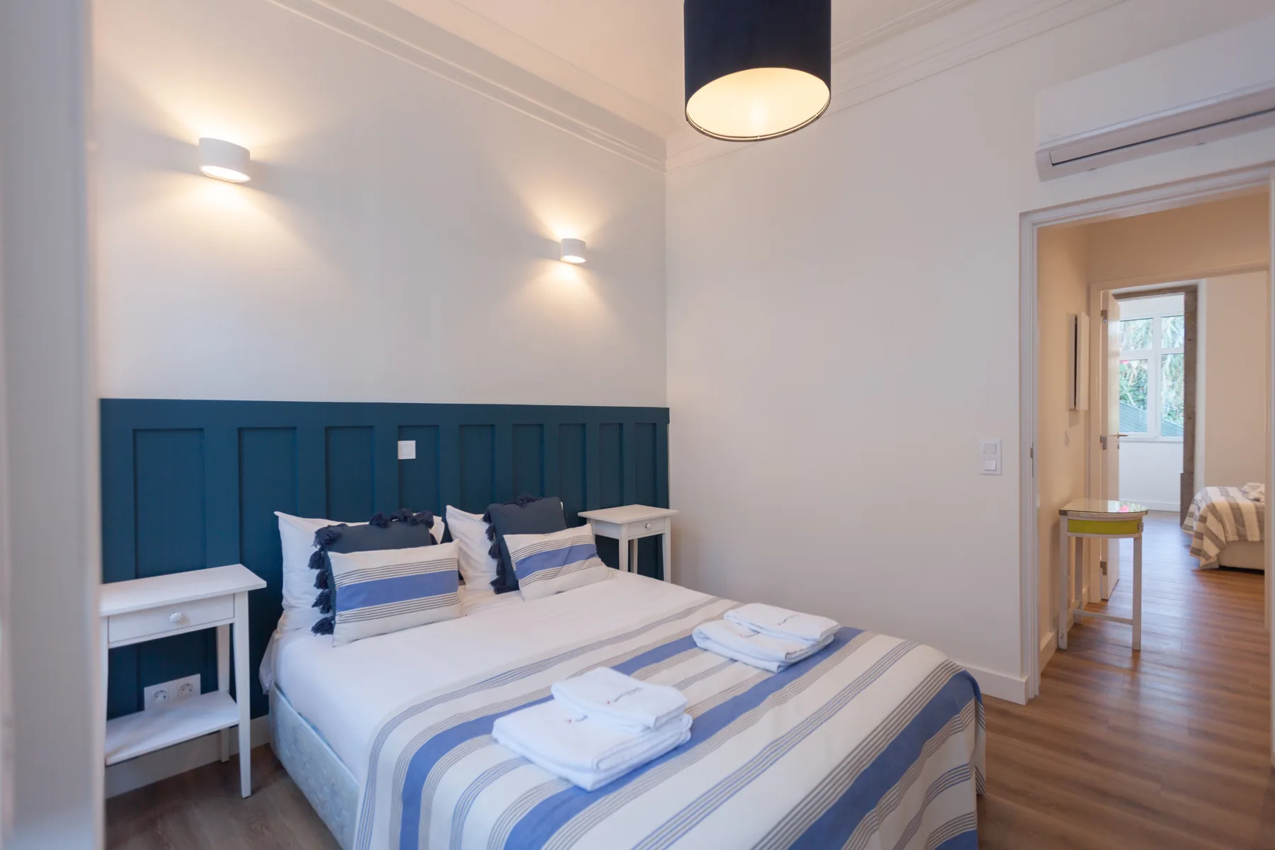 A bedroom with a double bed and blue headboard.