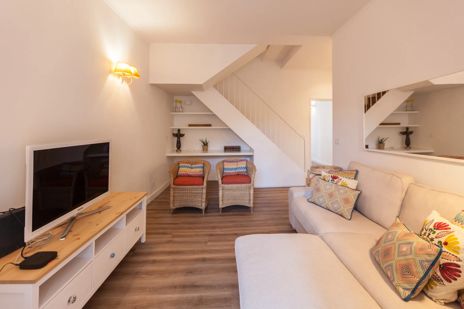 A living room with a television, seating, and a staircase.