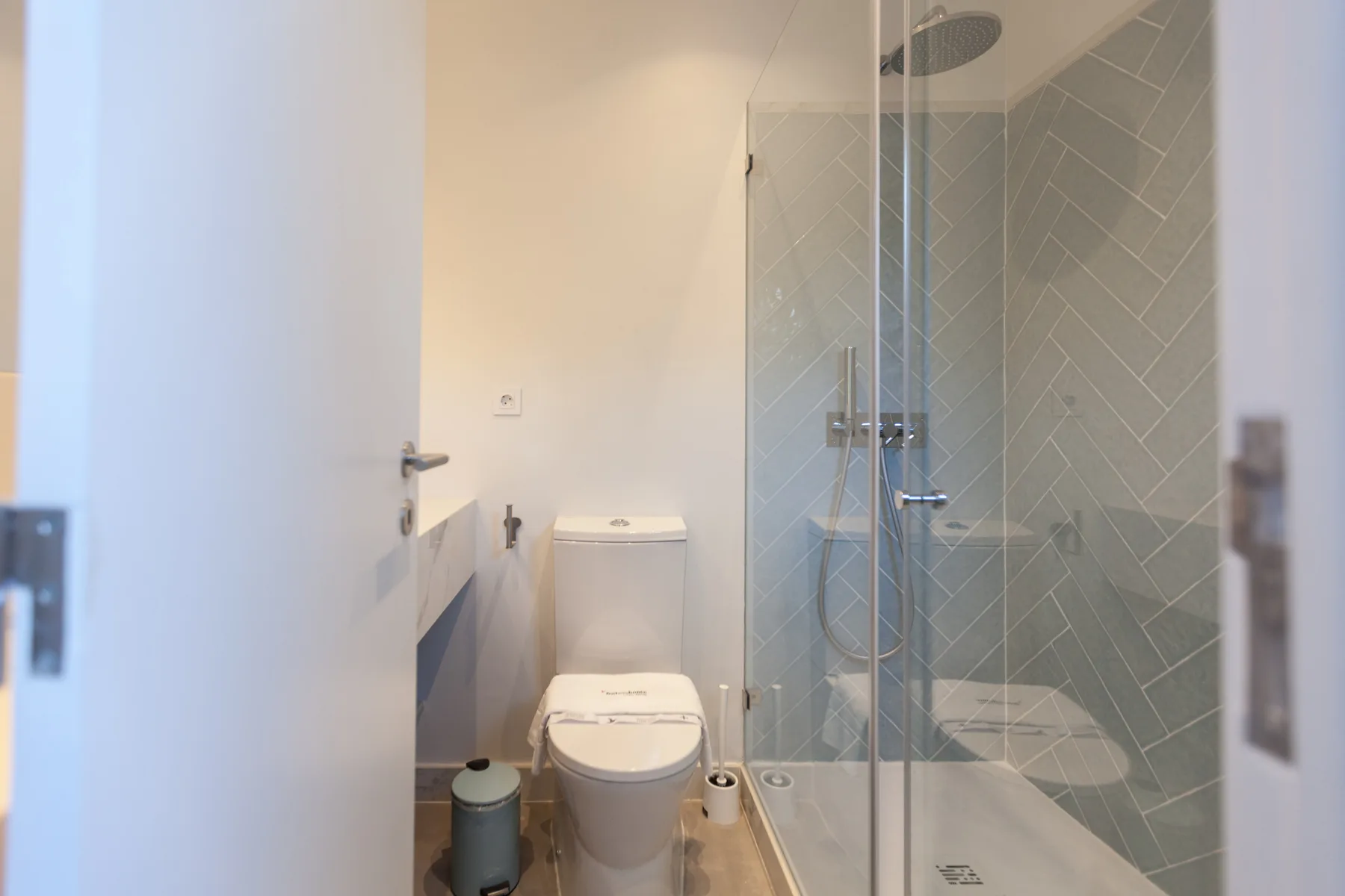 A bathroom with a toilet, sink, and glass-enclosed shower.