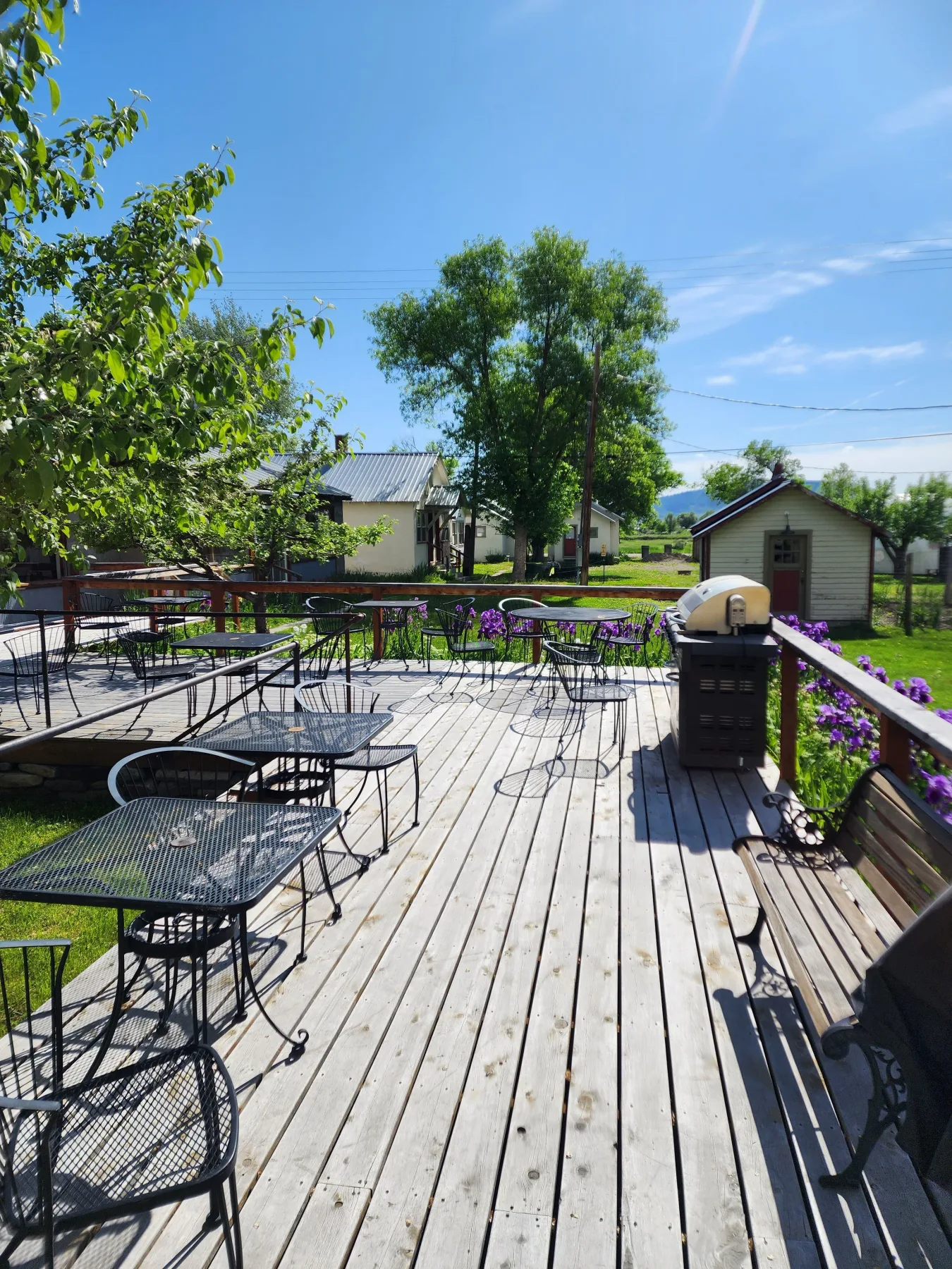 Patio exterior con mesas, sillas y parrilla