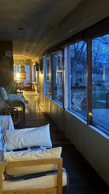 Sala acristalada con asientos y ventanas con vistas al jardín