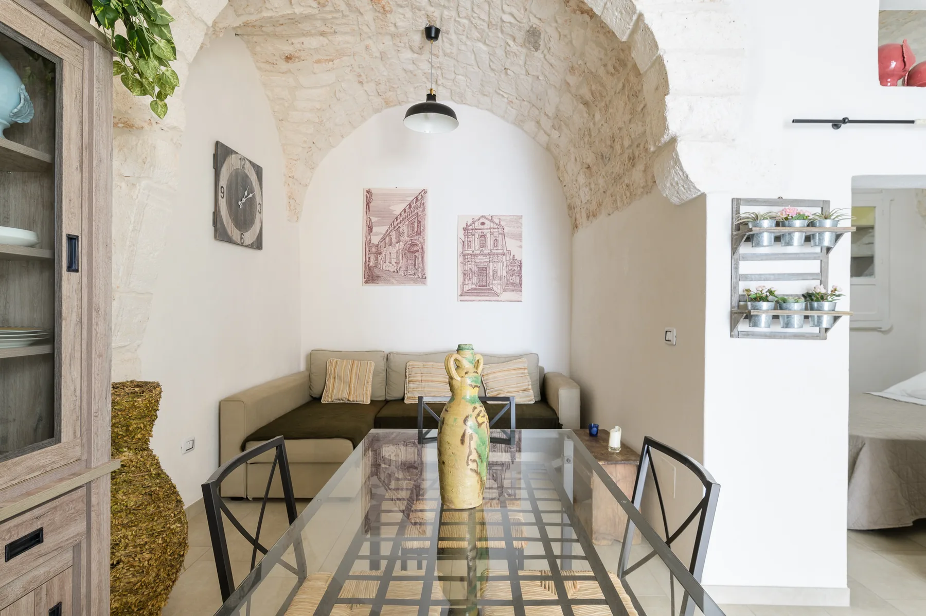 A dining area with glass-top seating beneath a stone arch.