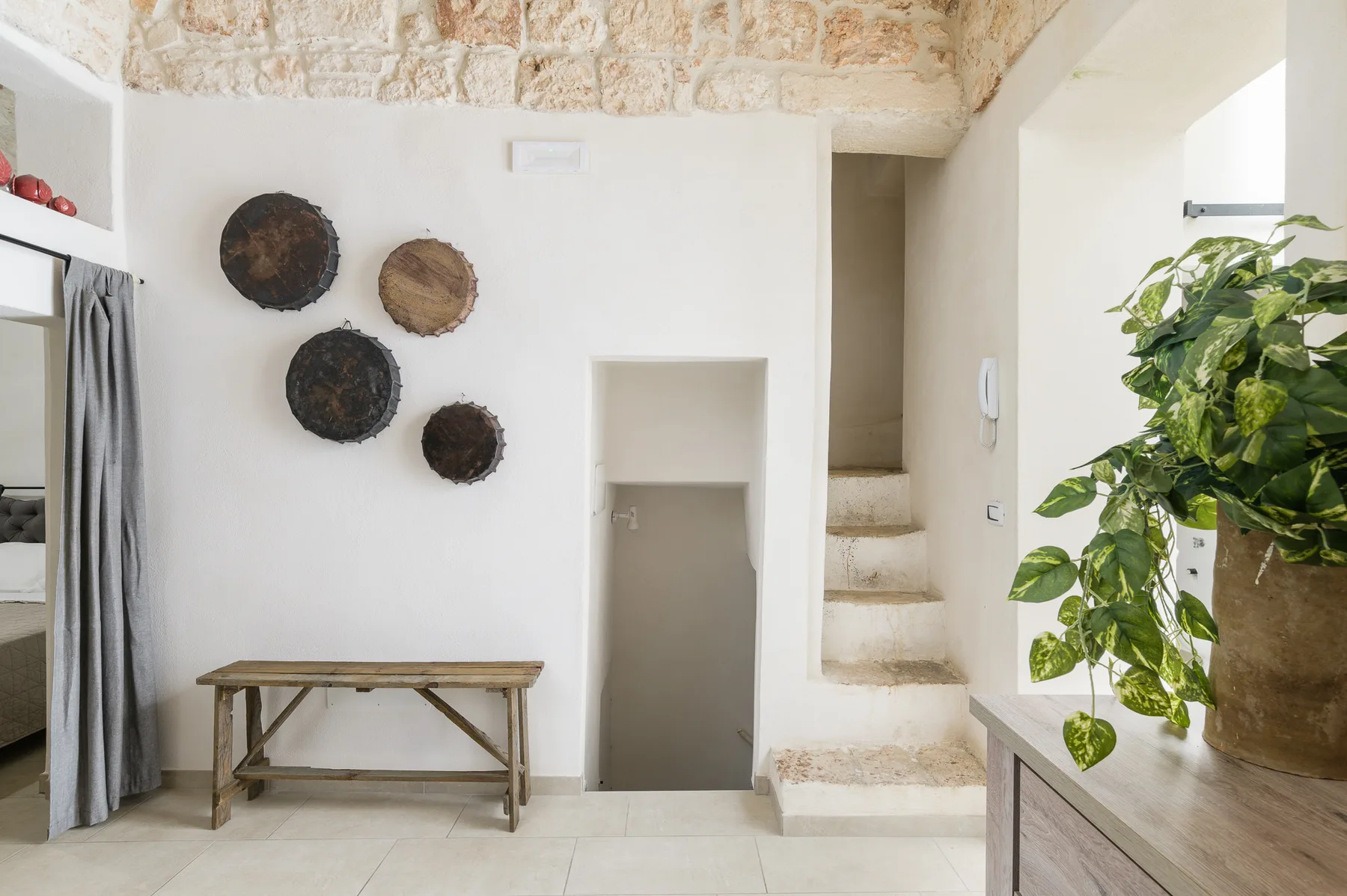 A bright interior entry area with a small bench and decorative wall pieces.