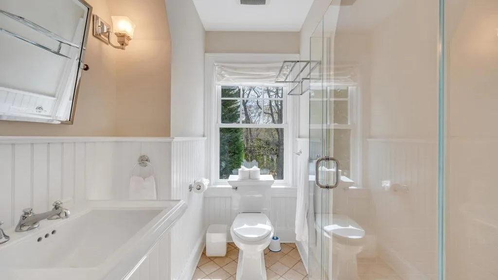 Un baño con bañera, inodoro y ventana.