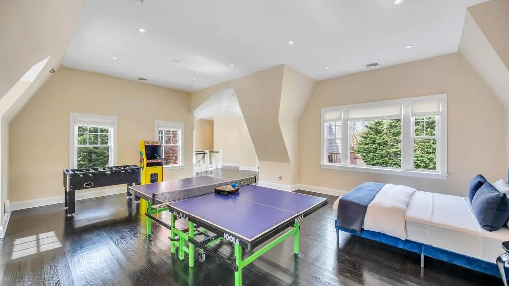 Una luminosa sala de recreación tiene una mesa de ping-pong y asientos junto a las ventanas.