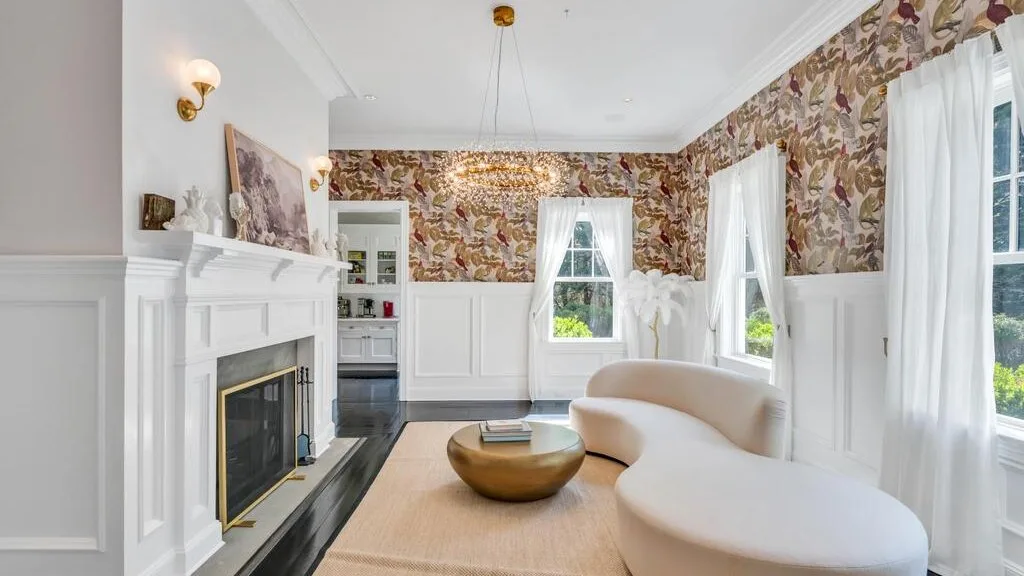 Una sala luminosa con chimenea blanca y asientos curvos.