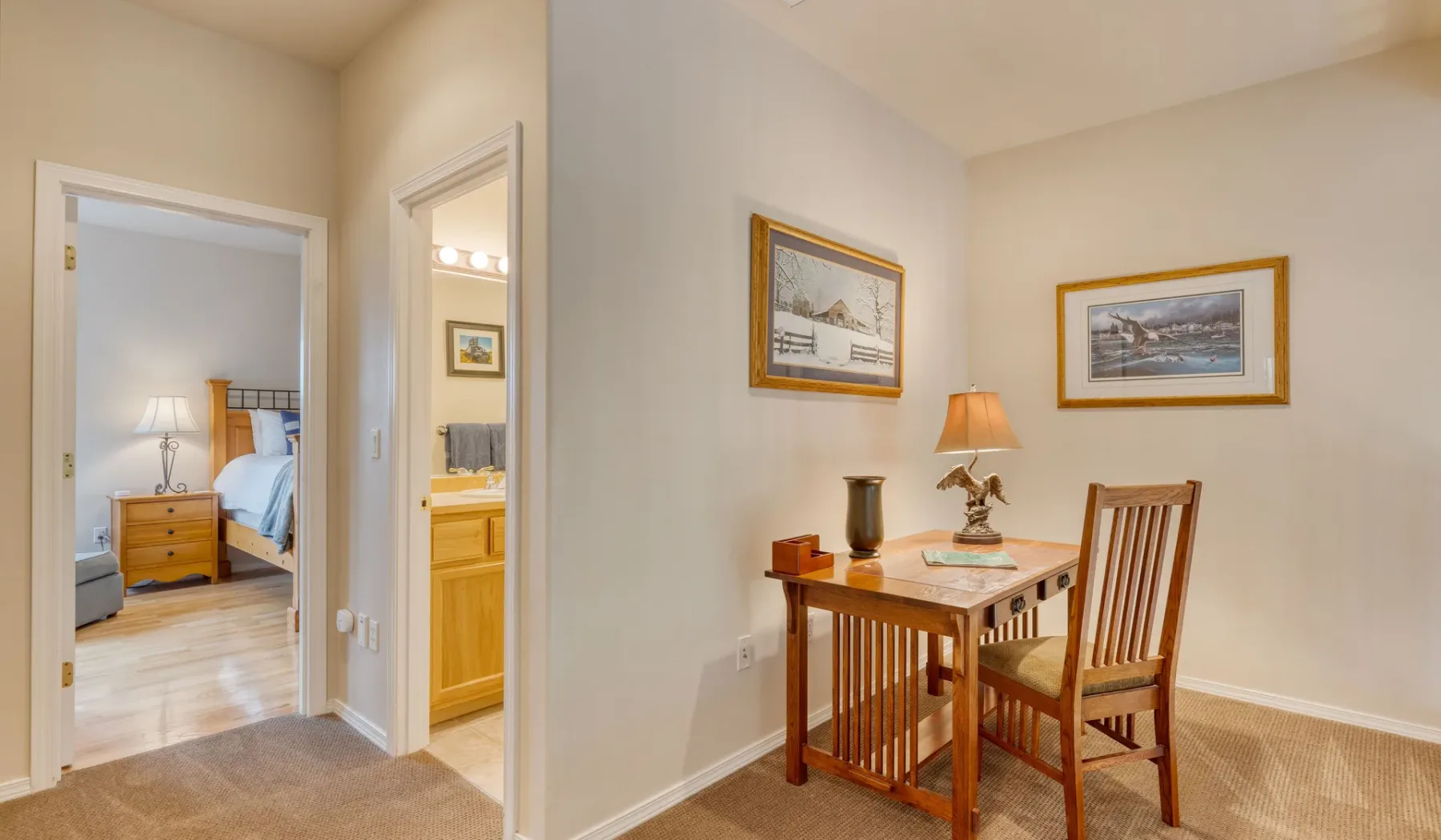 A dining area with a wooden table, chairs, and framed pictures on the walls.
