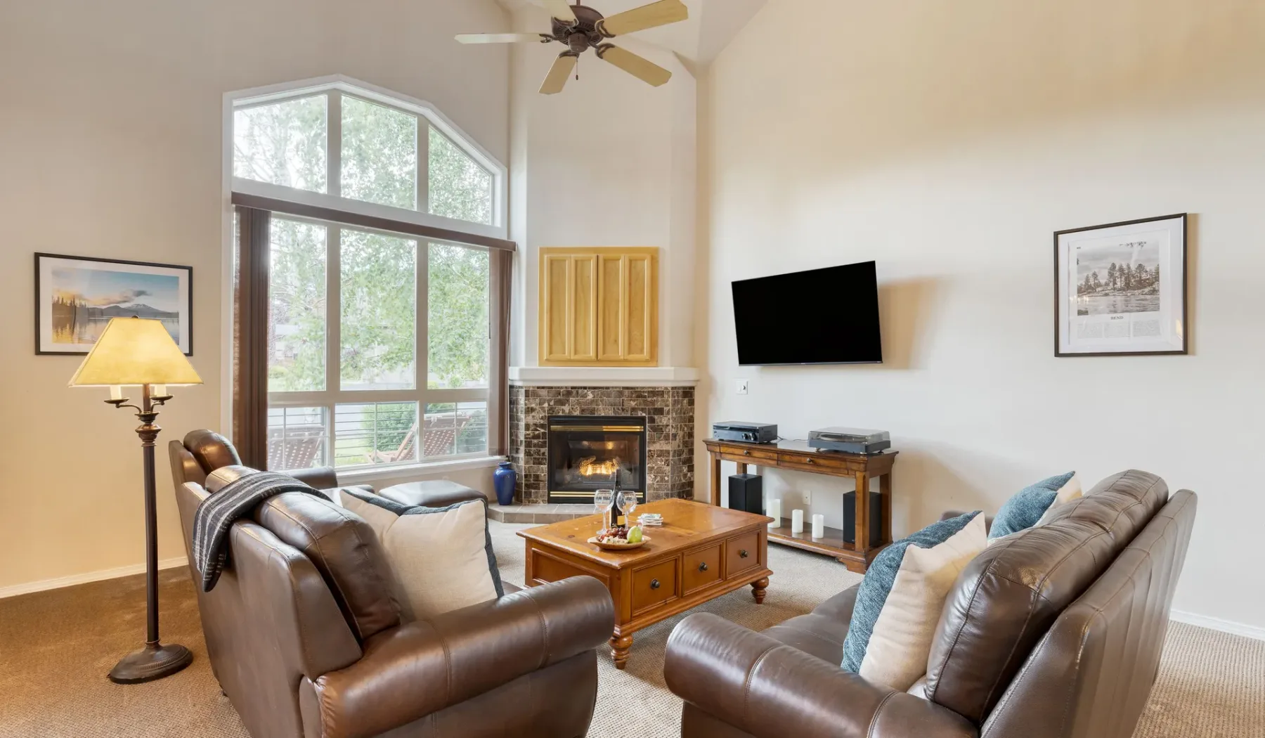 A living room with leather seating, a coffee table, and a fireplace.