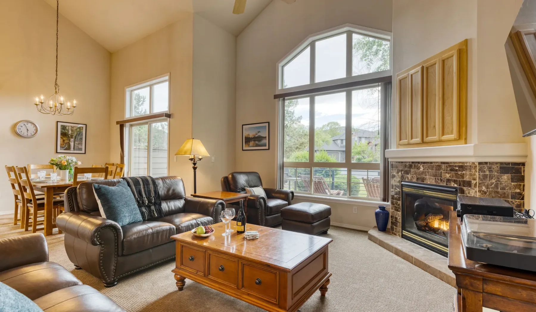 A living room with seating around a coffee table beside a fireplace.