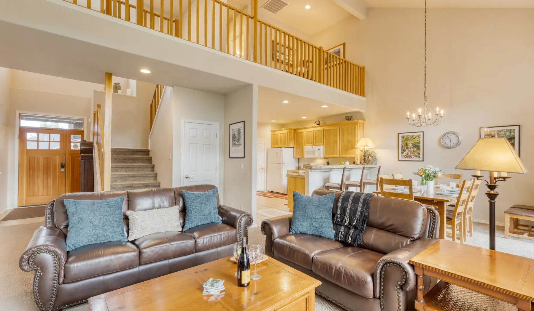 A bright open-plan living room with seating, a dining area, and a kitchen.
