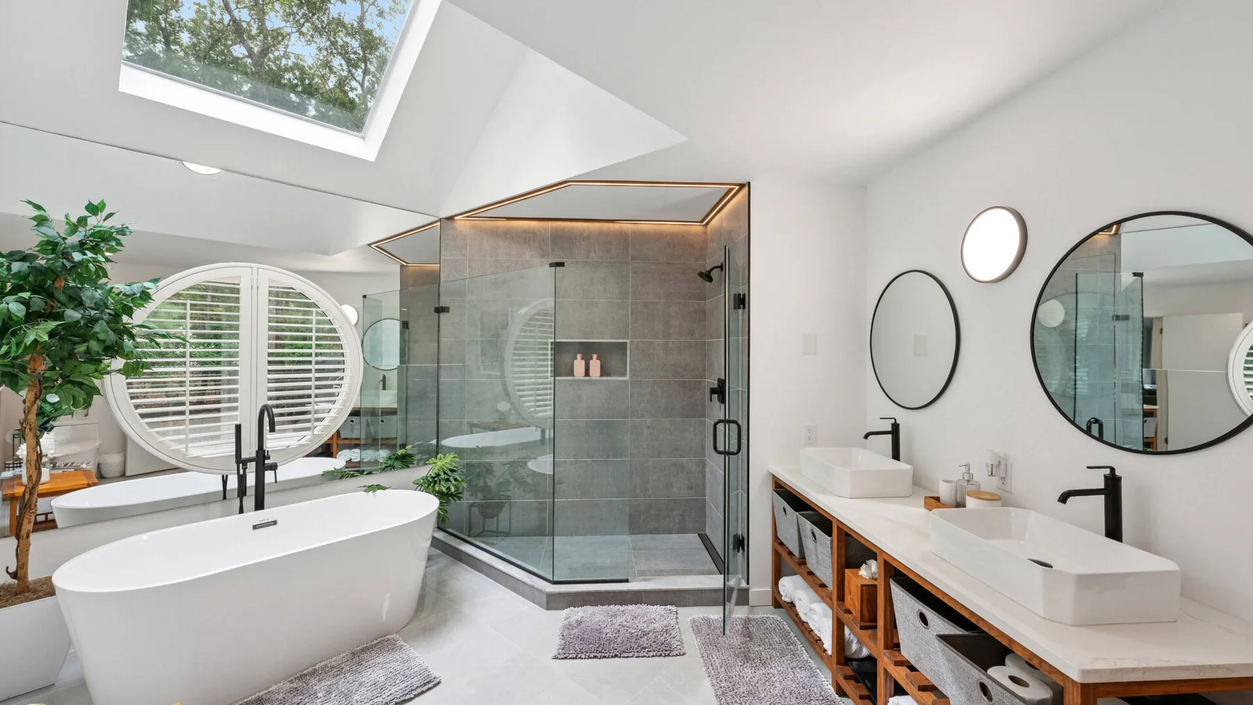 Un baño luminoso cuenta con una bañera exenta, una ducha de vidrio y un tocador doble.