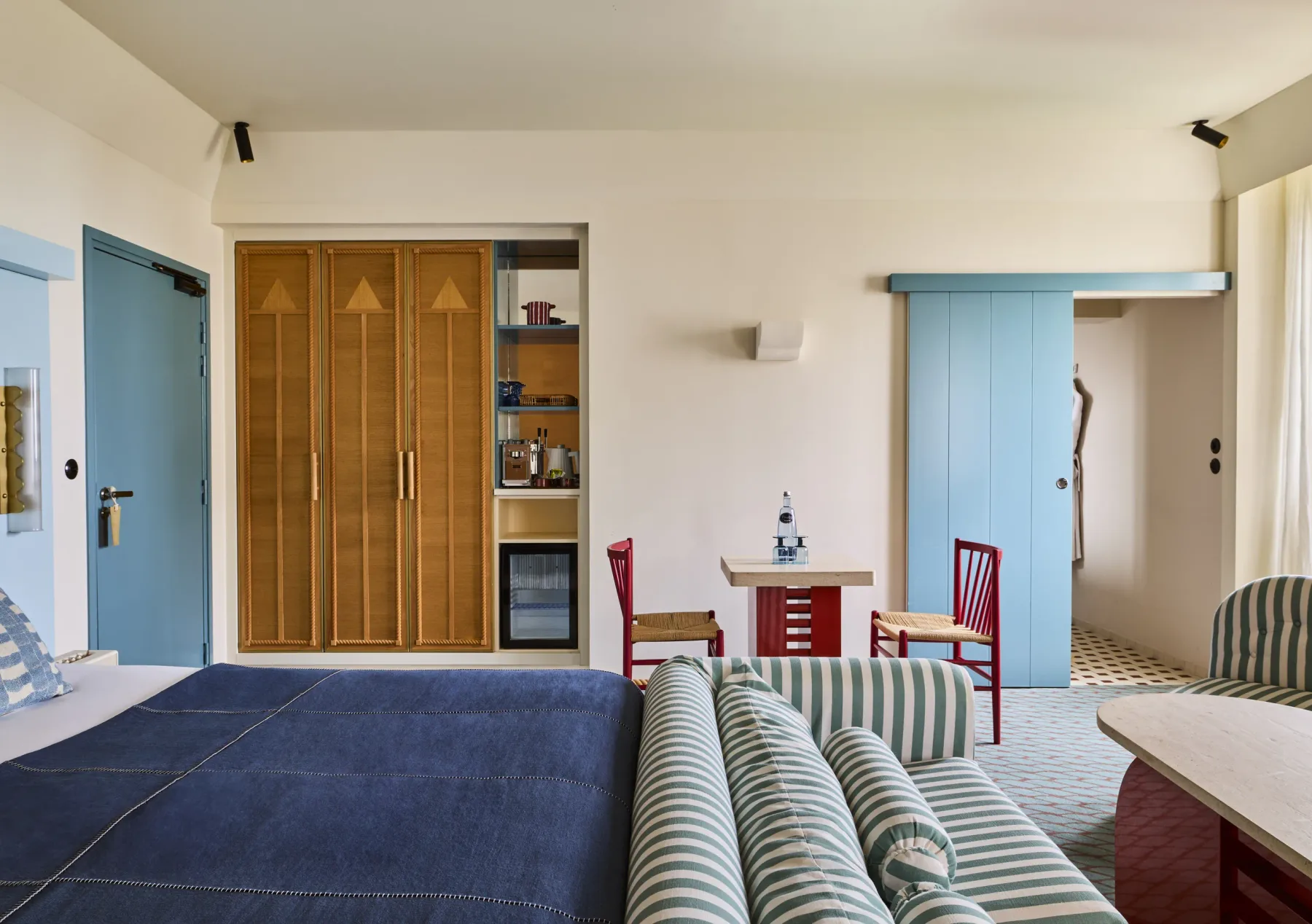 Habitación con detalles en verde azulado y armario de madera.