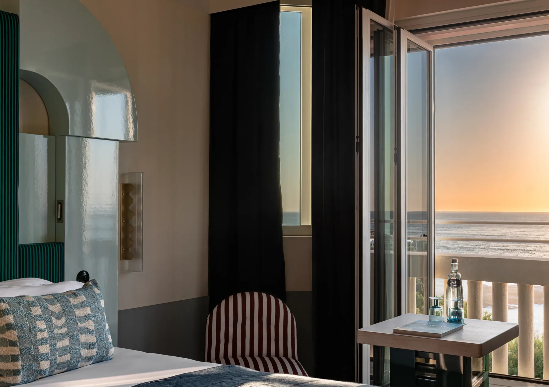 Habitación con vistas al océano al atardecer.