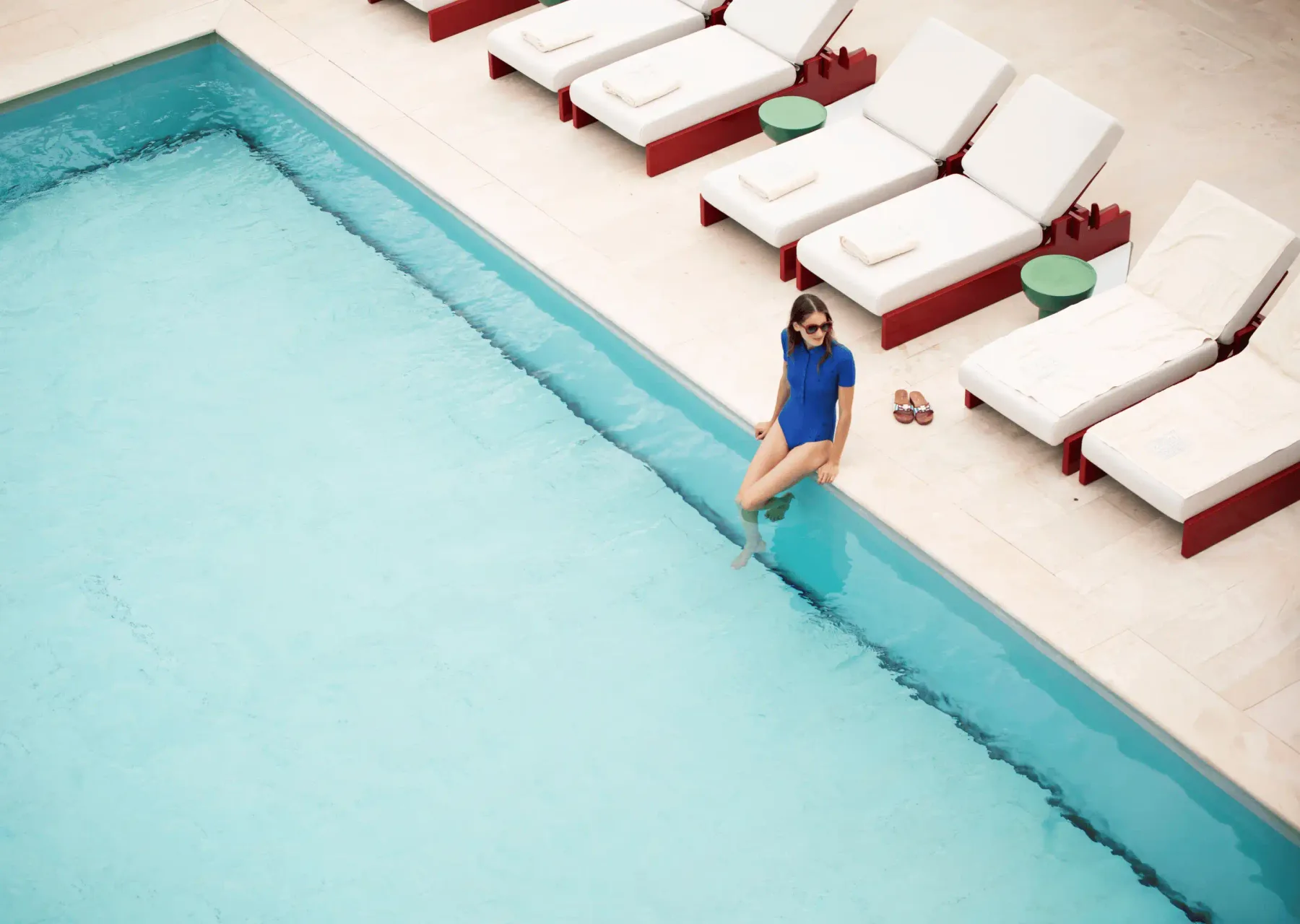 Piscina al aire libre con tumbonas.