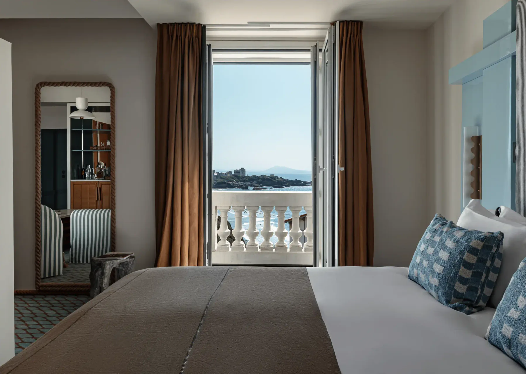 Habitación con salida a un balcón con vistas al mar.