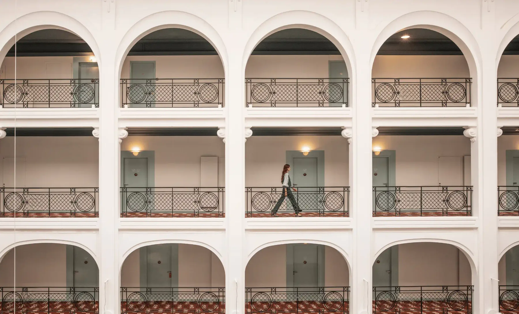 Pasillo del hotel con arcos y barandillas decorativas.