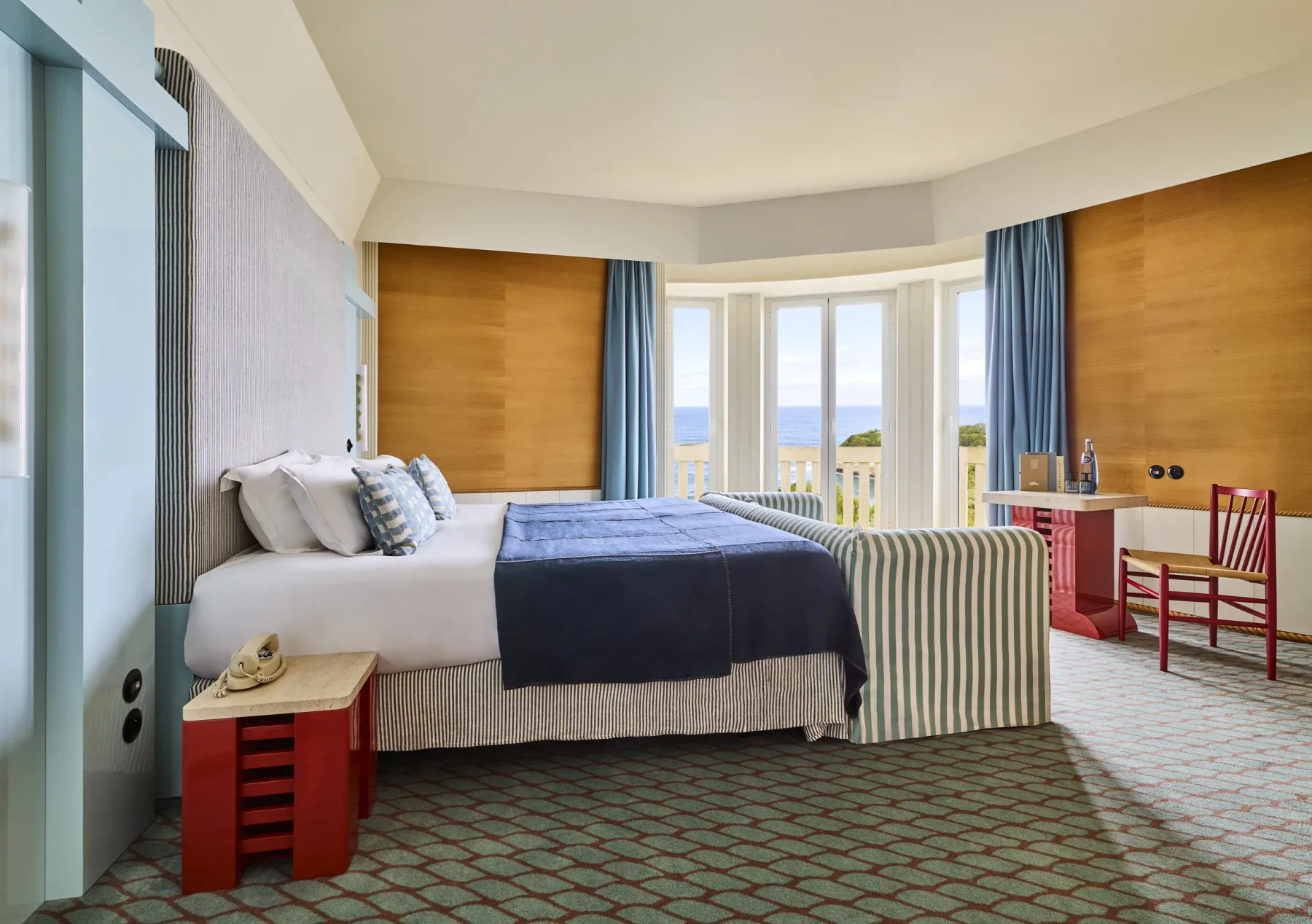 Habitación con revestimiento de madera de tonos cálidos y cortinas azules.