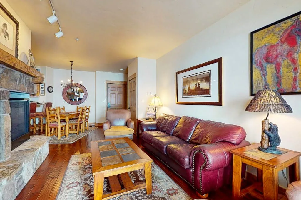 Una sala de estar con asientos de cuero, una mesa de centro de madera y un comedor.