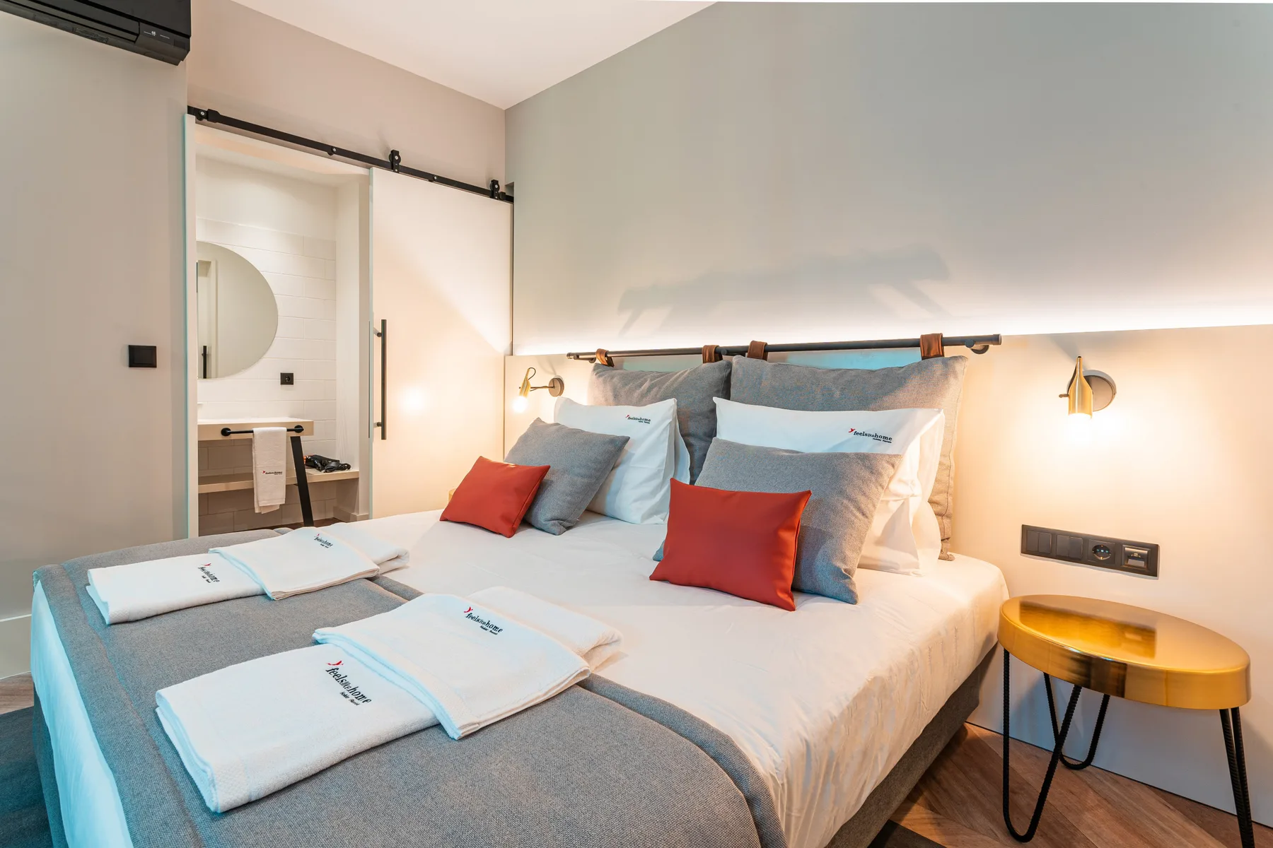 A bedroom with a neatly made bed and colorful accent pillows.