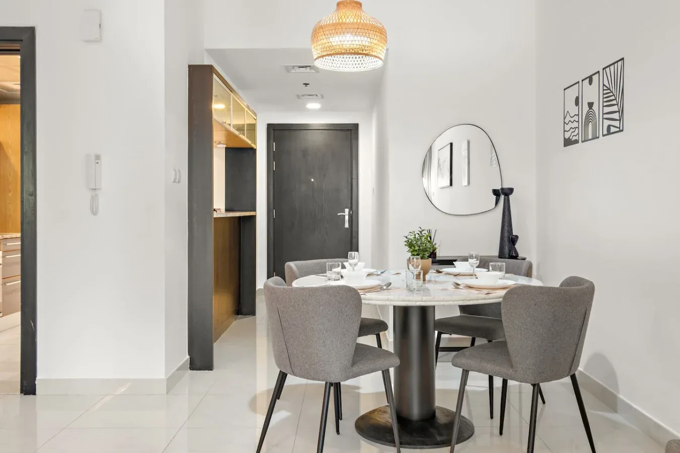 Comedor con una mesa redonda y asientos tapizados de color gris.