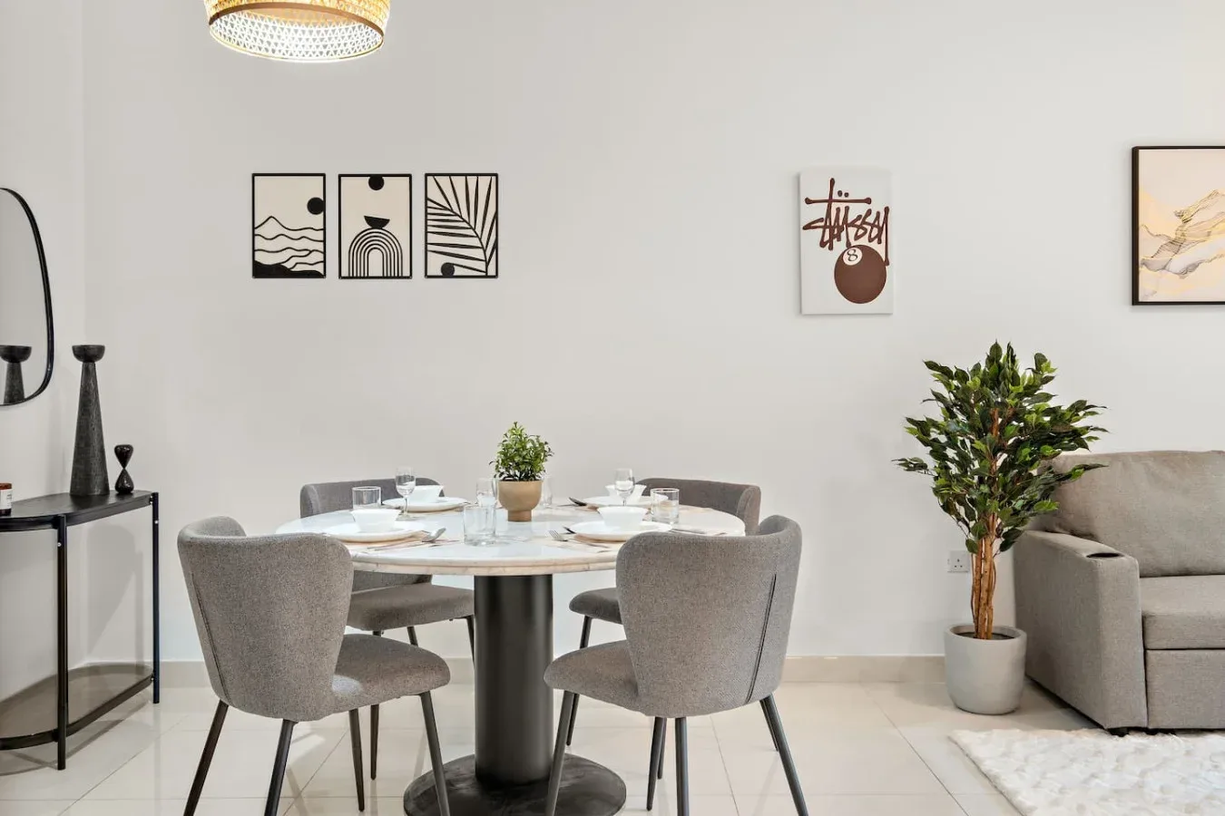 Un comedor con una mesa redonda junto a una zona de estar.
