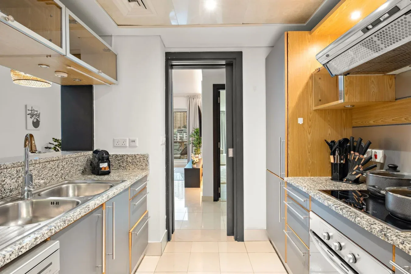 Una cocina estrecha con encimeras a ambos lados y una puerta al fondo.