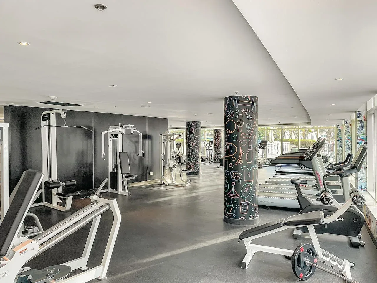Un gimnasio amplio con máquinas de ejercicio y cintas de correr.