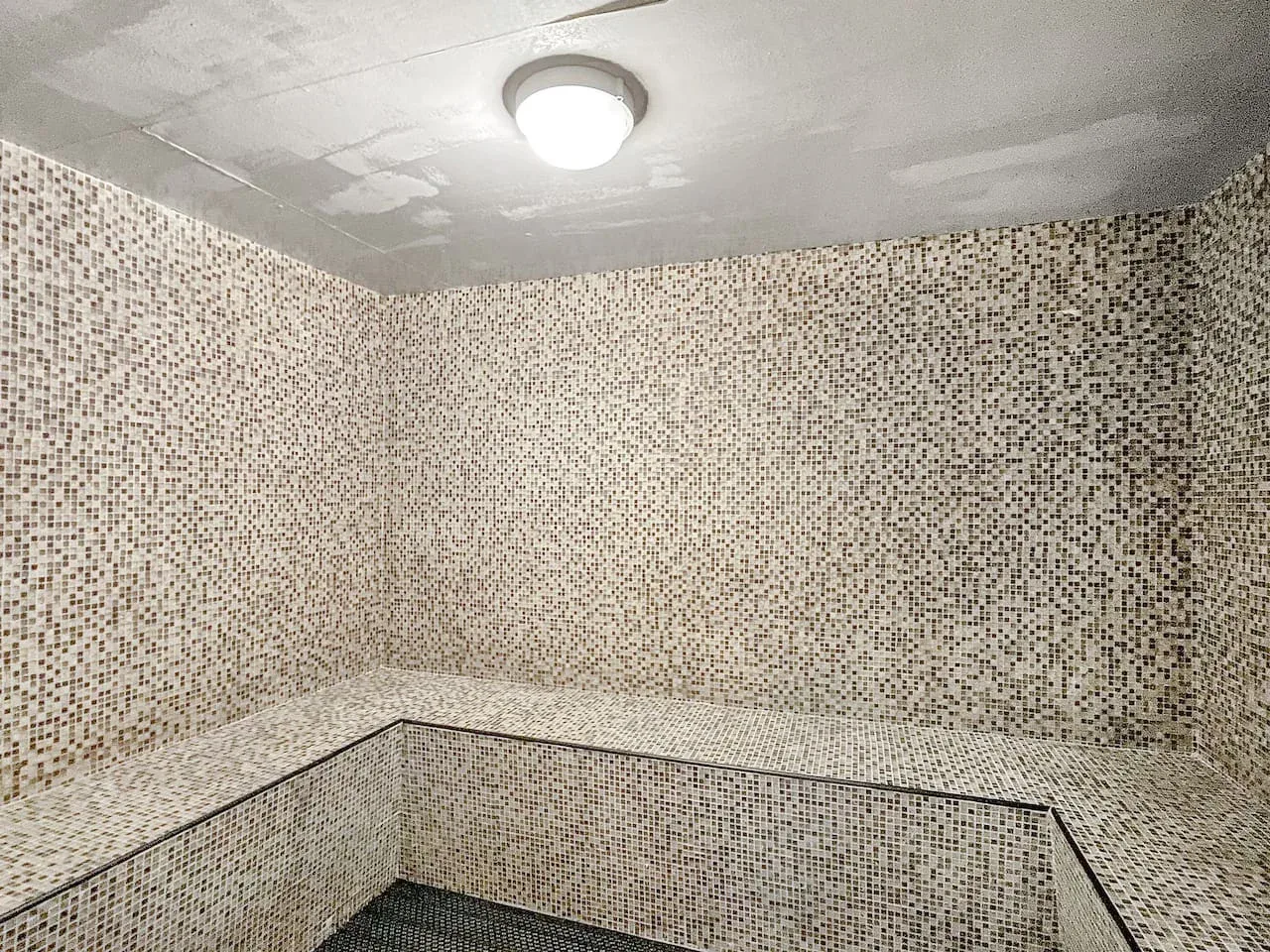 Un baño de vapor con banco integrado y luz en el techo.