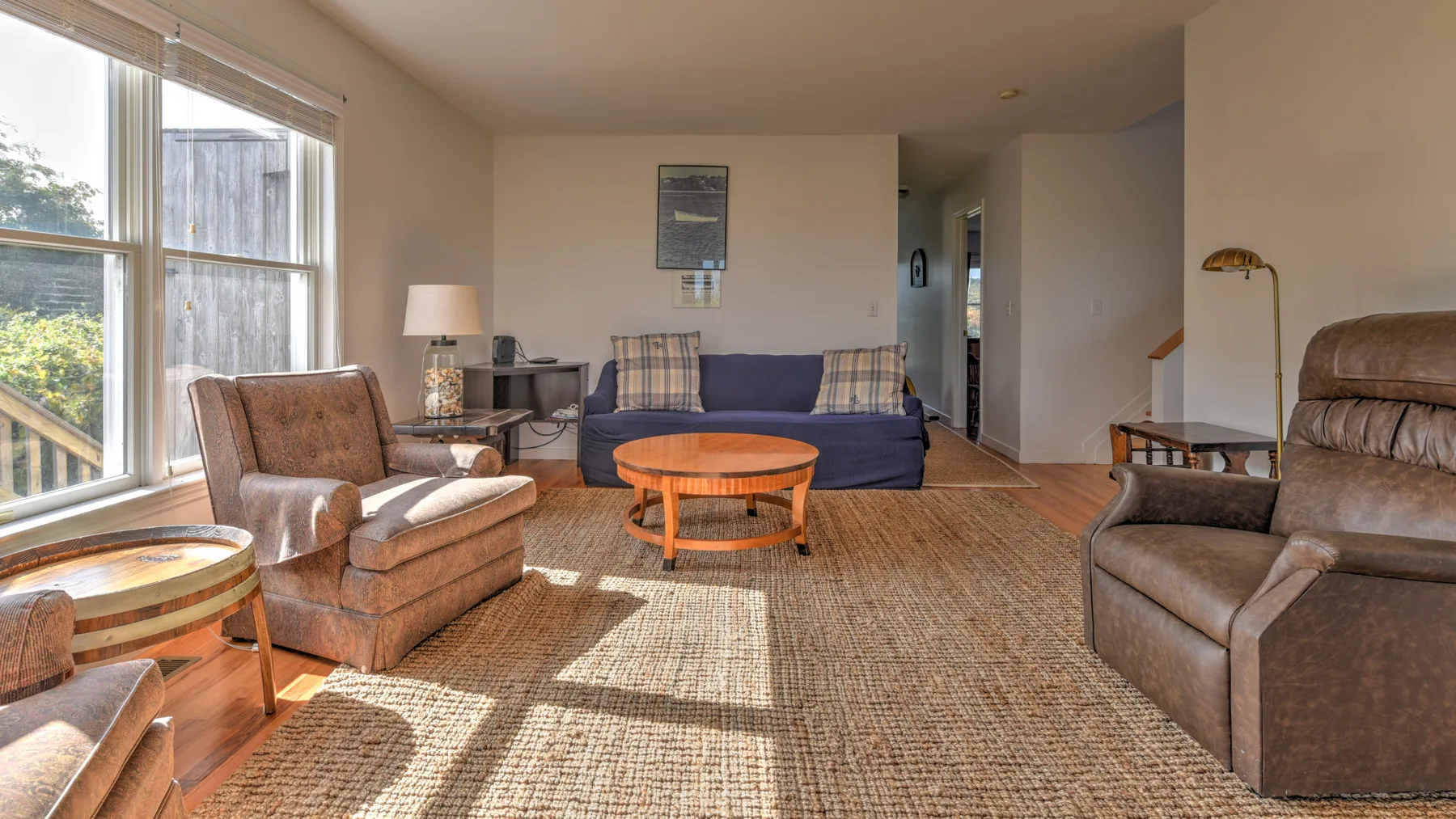 A living room with a blue sofa, armchairs, and a wooden coffee table.