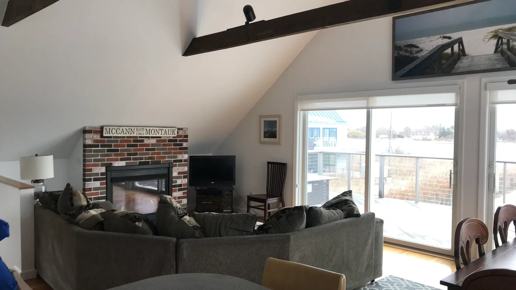 A living room with seating arranged around a fireplace and television.