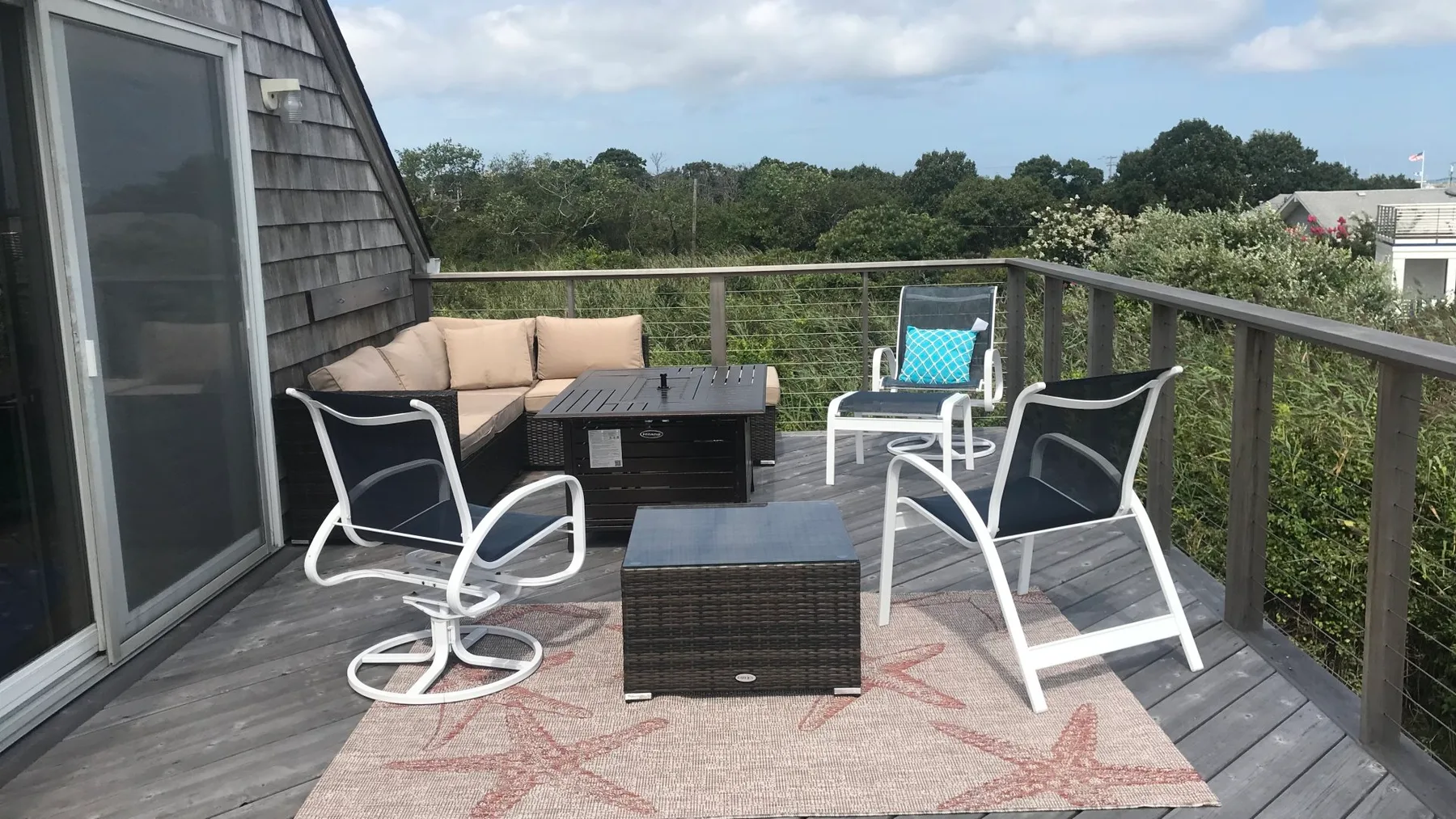 An outdoor deck seating area with lounge chairs, a bench, and a low table.