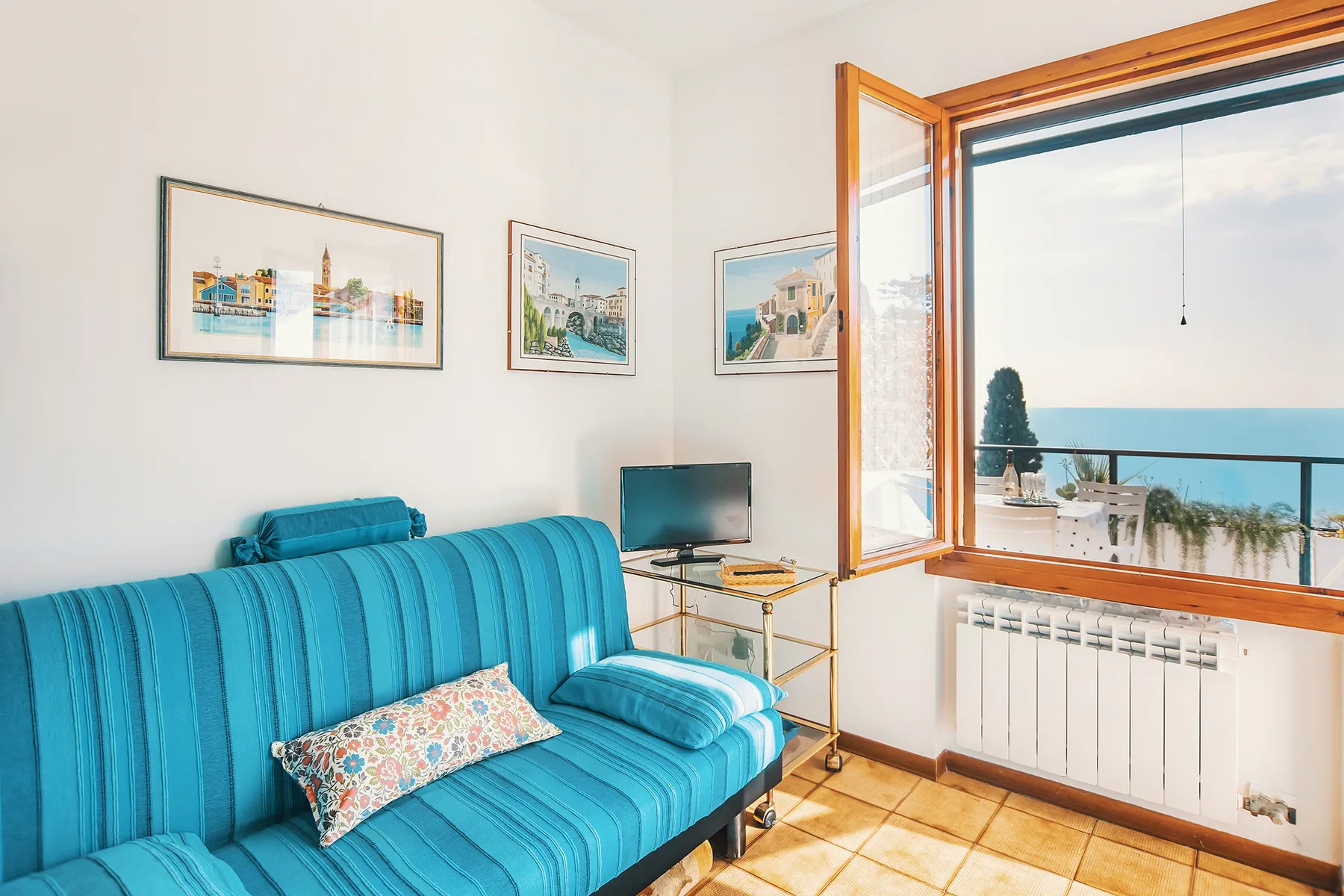 Una sala luminosa con asientos azules junto a una gran ventana abierta.