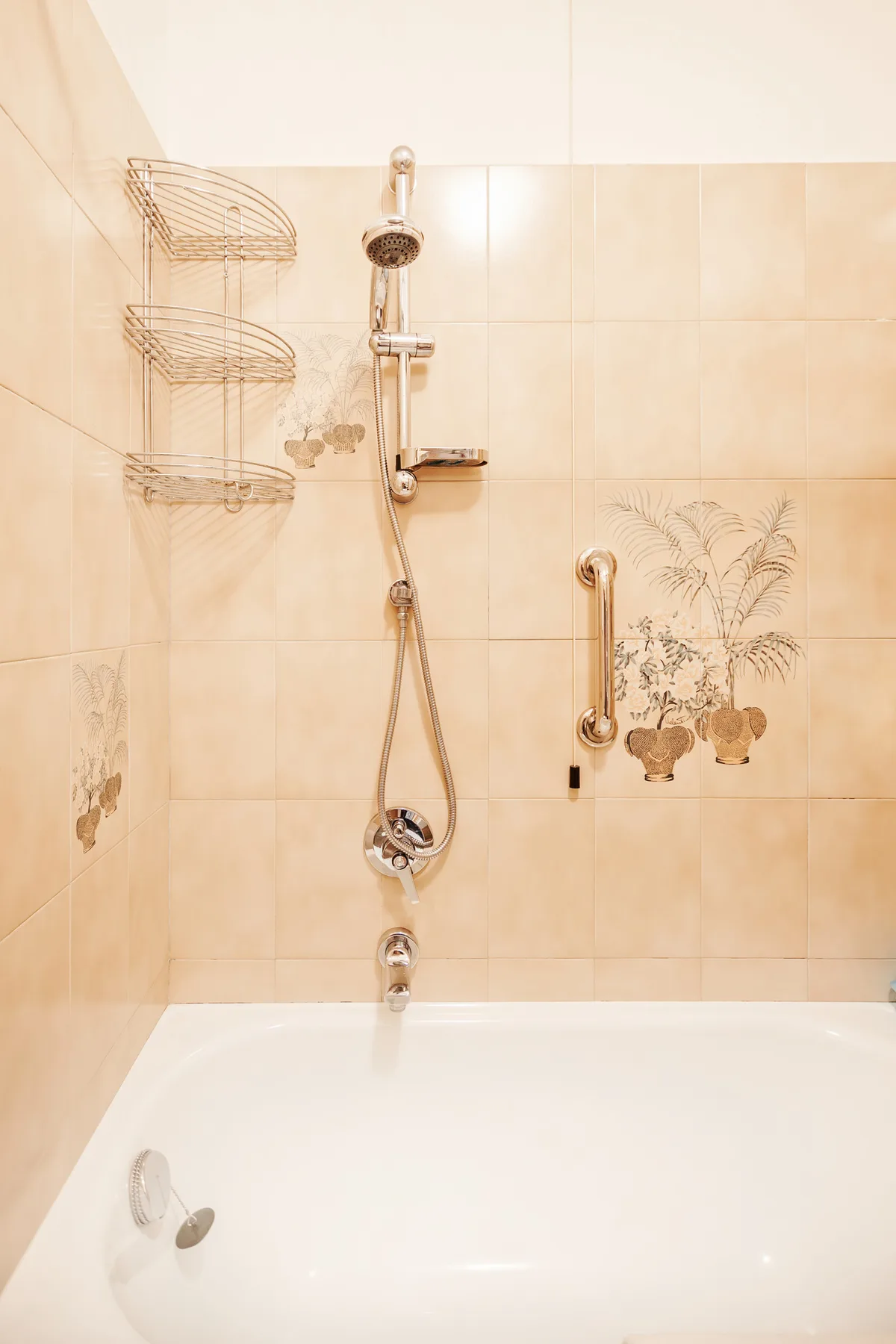 A tiled bathroom with a bathtub and wall-mounted shower.