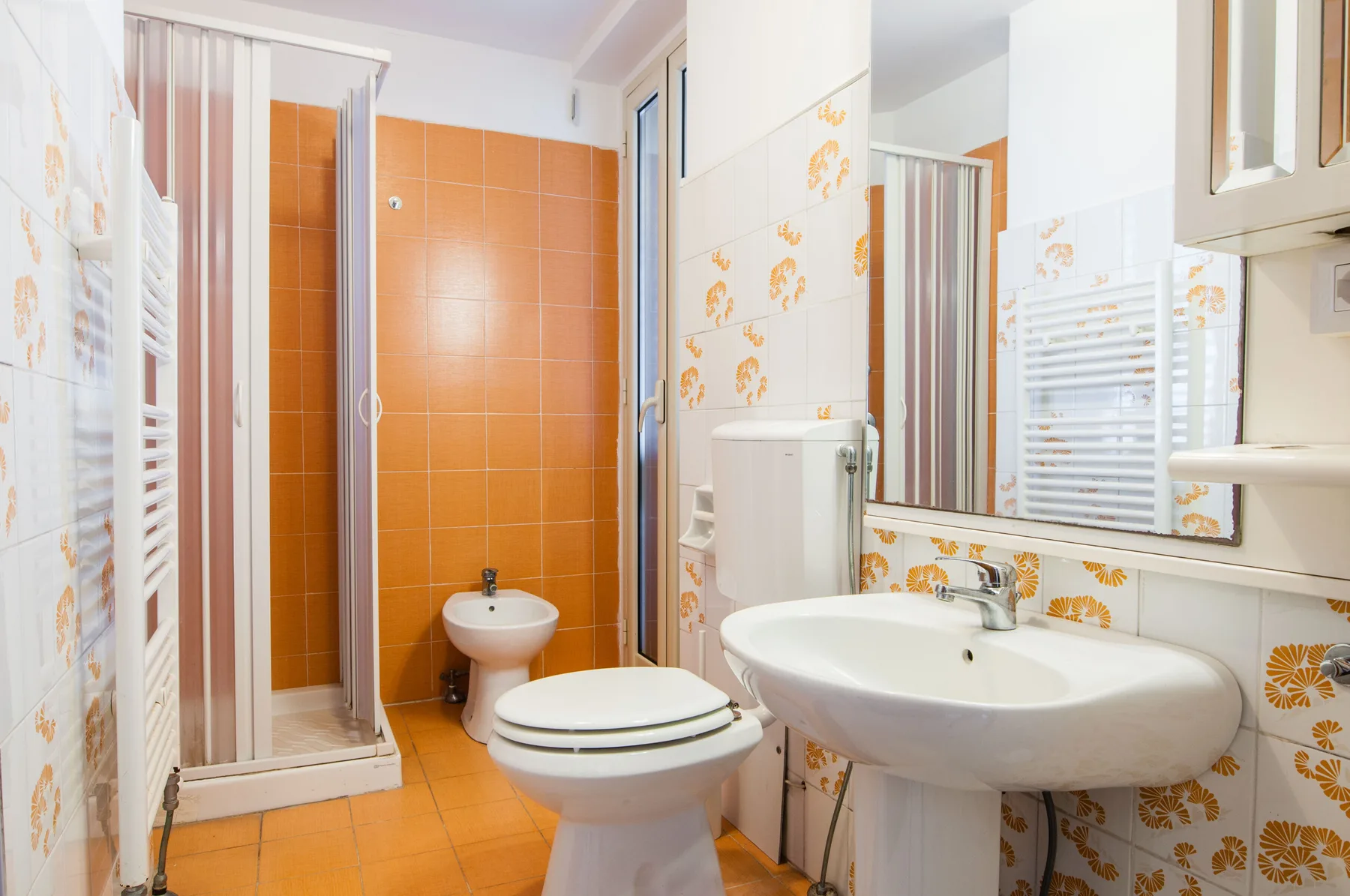 A bathroom with a bathtub-free shower, toilet, and sink.