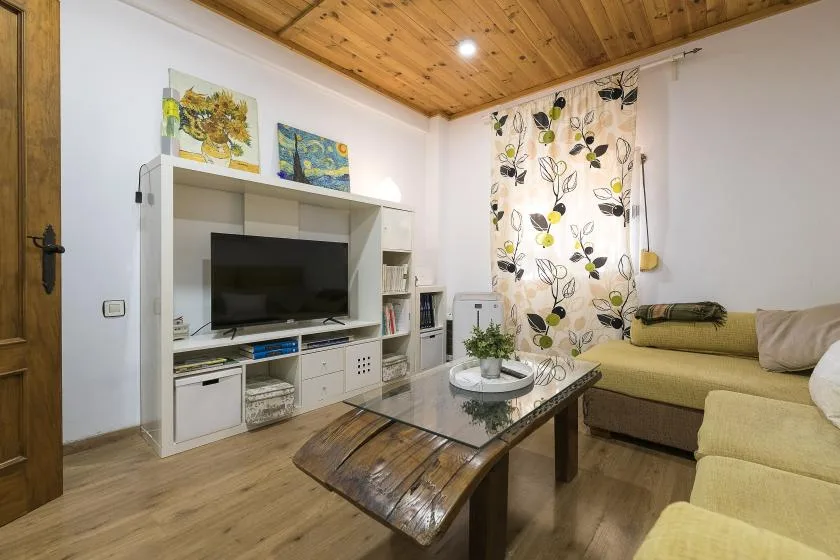 A living room with a television, low coffee table, and seating.