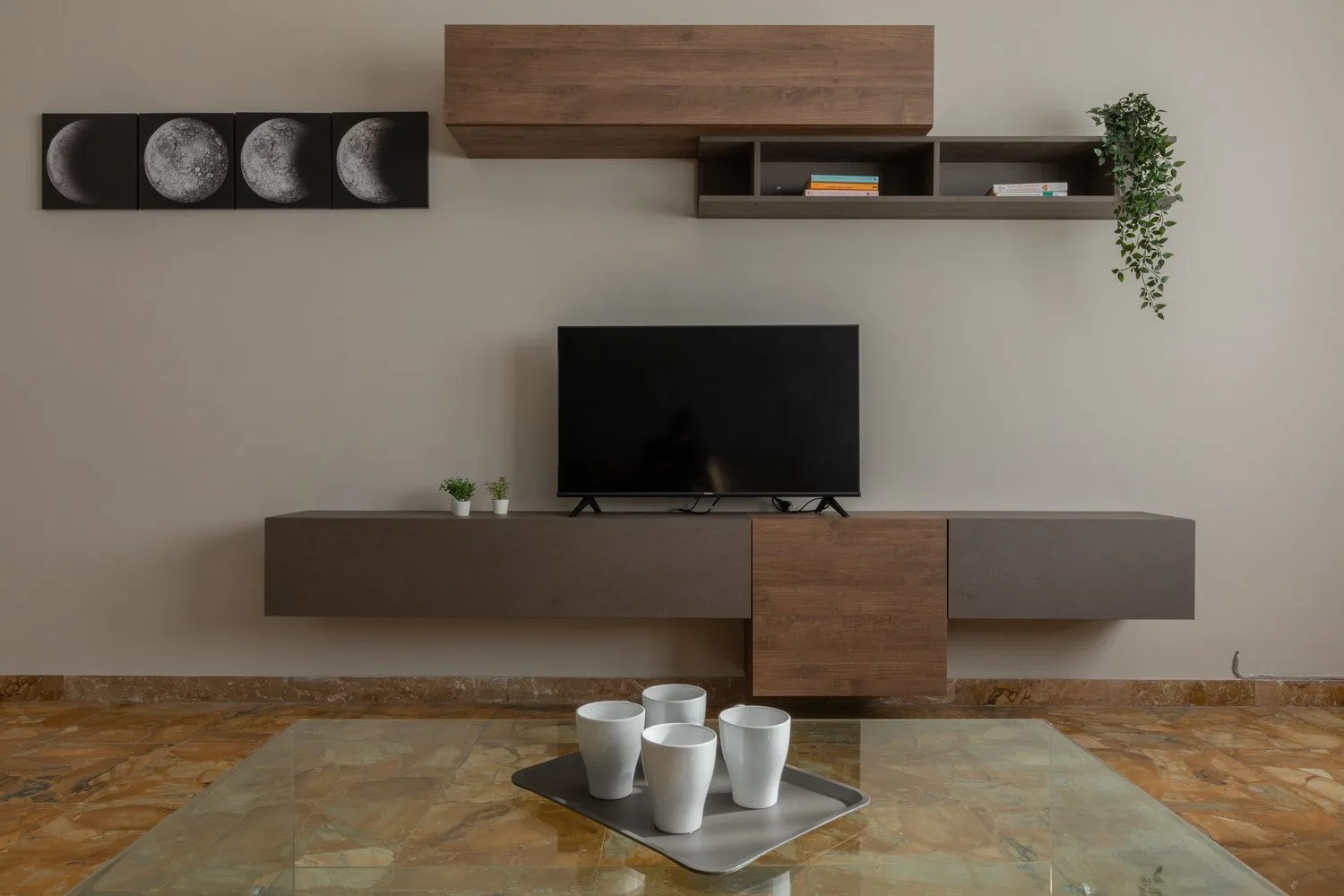 A living room with a television mounted above a low wall unit.