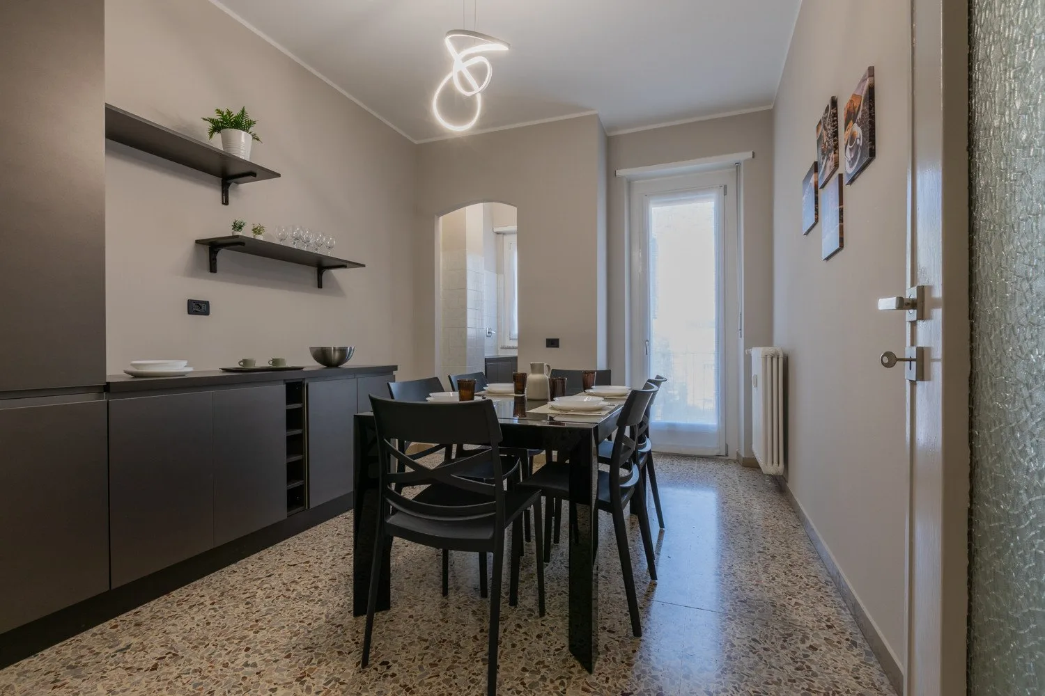 A dining area with a table and chairs beside a long cabinet.