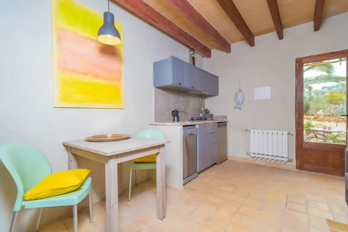 Comedor con una mesa pequeña, asientos y una cocina compacta.