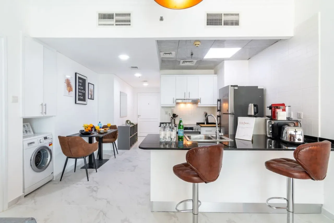 Una cocina y comedor luminosos con una barra y asientos.